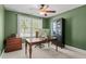 Home office with large window, wood desk, ceiling fan, and ample natural light at 5916 Two Pines Trl, Wake Forest, NC 27587