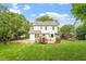 Spacious backyard with lush lawn, mature trees, and an inviting deck at 669 Tyler Run Dr, Wake Forest, NC 27587