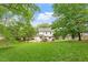 Expansive backyard featuring a well-manicured lawn, mature trees, and a charming white two-story home at 669 Tyler Run Dr, Wake Forest, NC 27587