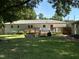 Large backyard with a wooden deck, swing, and mature shade trees at 704 S Mineral Springs Rd, Durham, NC 27703