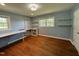 Spacious bedroom with hardwood floors, dual windows and bright blue walls and trim at 704 S Mineral Springs Rd, Durham, NC 27703