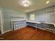Bright bedroom with hardwood floors, natural light and custom-built shelving and work space at 704 S Mineral Springs Rd, Durham, NC 27703