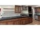 Modern kitchen featuring dark wood cabinets, a black countertop, and stainless steel appliances at 704 S Mineral Springs Rd, Durham, NC 27703