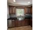 Modern kitchen featuring a stainless steel sink, dark countertops, and wood cabinets at 704 S Mineral Springs Rd, Durham, NC 27703