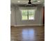 Bright living room with hardwood floors and large windows overlooking the front yard at 704 S Mineral Springs Rd, Durham, NC 27703