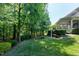 Lush green backyard featuring mature trees and an outdoor living space with a screened-in porch at 713 Liberty Cliff Dr, Cary, NC 27519