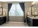 Bathroom featuring double sinks, granite countertop, dark wood cabinets, and a window with natural light at 713 Liberty Cliff Dr, Cary, NC 27519