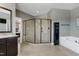 Modern bathroom showcasing a glass-enclosed shower, soaking tub, dark cabinets and granite countertops at 713 Liberty Cliff Dr, Cary, NC 27519