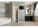 Well-lit bathroom boasting a soaking tub, tile, and vanity with a large mirror and TV at 713 Liberty Cliff Dr, Cary, NC 27519