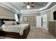 Bedroom with tray ceilings, large bed, and two windows at 713 Liberty Cliff Dr, Cary, NC 27519