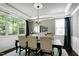 Bright dining room with a chandelier, large windows, decorative mirror and neutral colored walls at 713 Liberty Cliff Dr, Cary, NC 27519