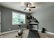 Well-lit exercise room featuring a treadmill, stationary bike, weights, and a ceiling fan at 713 Liberty Cliff Dr, Cary, NC 27519