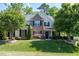 Charming two-story home with stone accents, a landscaped yard, and mature trees at 713 Liberty Cliff Dr, Cary, NC 27519