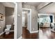 A hallway showcasing hardwood floors and leading to a bathroom and living area with ample natural light at 713 Liberty Cliff Dr, Cary, NC 27519
