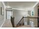 Upstairs hallway with wrought iron railing, neutral carpeting, and crown molding at 713 Liberty Cliff Dr, Cary, NC 27519