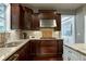 Modern kitchen with granite countertops, dark wood cabinetry, stainless sink, and brick backsplash at 713 Liberty Cliff Dr, Cary, NC 27519