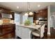 Open kitchen featuring granite counters, stainless appliances, and a large island with stylish pendant lighting at 713 Liberty Cliff Dr, Cary, NC 27519