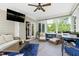 Bright sunroom with ample seating, ceiling fan, television, and views of the backyard at 713 Liberty Cliff Dr, Cary, NC 27519
