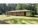 Brick home with a lush green backyard, mature trees, and screened porch at 725-727 Locust Ln, Raleigh, NC 27603