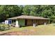 Brick home with a lush green backyard, mature trees, and screened porch at 725-727 Locust Ln, Raleigh, NC 27603