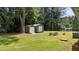 Backyard with mature trees and storage sheds providing extra storage space at 725-727 Locust Ln, Raleigh, NC 27603