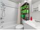Well-lit bathroom with combined shower and tub and a modern shelving unit at 725-727 Locust Ln, Raleigh, NC 27603