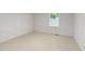 Simple bedroom with light walls and flooring and a window for natural light at 725-727 Locust Ln, Raleigh, NC 27603