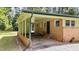 View of the covered carport with brick siding, adjacent to the entrance of unit 725 at 725-727 Locust Ln, Raleigh, NC 27603