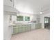 A bright kitchen with light-green cabinets, wooden counters, and stainless steel backsplash at 725-727 Locust Ln, Raleigh, NC 27603