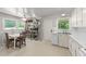 Well-lit kitchen featuring white cabinets, marble countertops, and modern appliances and a dining area at 725-727 Locust Ln, Raleigh, NC 27603