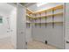 A spacious walk-in closet featuring wooden shelves and vinyl flooring at 725-727 Locust Ln, Raleigh, NC 27603