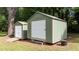 Yard with two sheds, one with a roll-up door and the other with a standard door, set amongst mature trees at 725-727 Locust Ln, Raleigh, NC 27603