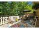Inviting back patio with outdoor seating, complemented by a vibrant rug and a lush backdrop of trees at 7918 Yester Ct, Raleigh, NC 27615