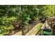 View of the backyard featuring a black metal fence and lush trees, creating a private outdoor space at 7918 Yester Ct, Raleigh, NC 27615