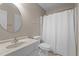 Cozy bathroom featuring a round mirror, standard toilet, and shower with curtain at 7918 Yester Ct, Raleigh, NC 27615
