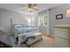 Bright bedroom featuring a ceiling fan, large window, and white paneled bed with floral bedding at 7918 Yester Ct, Raleigh, NC 27615