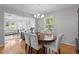 Dining area with wood floors, table, six chairs, and an open view to the living room at 7918 Yester Ct, Raleigh, NC 27615