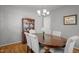 Elegant dining room with a wood table, cushioned chairs, hardwood floors, and a decorative chandelier at 7918 Yester Ct, Raleigh, NC 27615