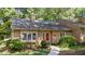 Charming home featuring a red front door, well-maintained landscaping, and a concrete walkway to the entrance at 7918 Yester Ct, Raleigh, NC 27615