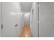 Hallway with multiple doors, light gray walls, and wood flooring, providing access to different rooms at 7918 Yester Ct, Raleigh, NC 27615