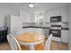 Kitchen area with white cabinets, stainless appliances, and a breakfast table and chairs at 7918 Yester Ct, Raleigh, NC 27615