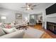 Open-concept living room with fireplace, sofa, adjacent dining room, and hardwood floors at 7918 Yester Ct, Raleigh, NC 27615