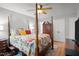 Bedroom with a four-poster bed, colorful bedding, hardwood floors, and closet storage at 7918 Yester Ct, Raleigh, NC 27615