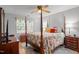 Bedroom with a four-poster bed, colorful bedding, hardwood floors, and sunny window at 7918 Yester Ct, Raleigh, NC 27615