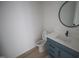 Powder room featuring a blue vanity with a modern sink and a round mirror at 7932 Wexford Waters Ln, Wake Forest, NC 27587
