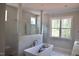 Modern bathroom featuring marble-like tile, a free-standing tub, and a spacious glass-enclosed shower at 7932 Wexford Waters Ln, Wake Forest, NC 27587