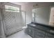 Modern bathroom showcasing gray tiled shower and vanity with drawers and countertop sink at 7932 Wexford Waters Ln, Wake Forest, NC 27587