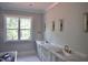 Bright bathroom with marble counters, dual sinks, and bronze fixtures is bathed in natural light at 7932 Wexford Waters Ln, Wake Forest, NC 27587