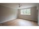 Sunlit bedroom with wood floors, a ceiling fan, and a large window with a wooded view at 7932 Wexford Waters Ln, Wake Forest, NC 27587