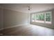 Large bedroom with a ceiling fan, light wood floors, and windows providing a wooded view at 7932 Wexford Waters Ln, Wake Forest, NC 27587